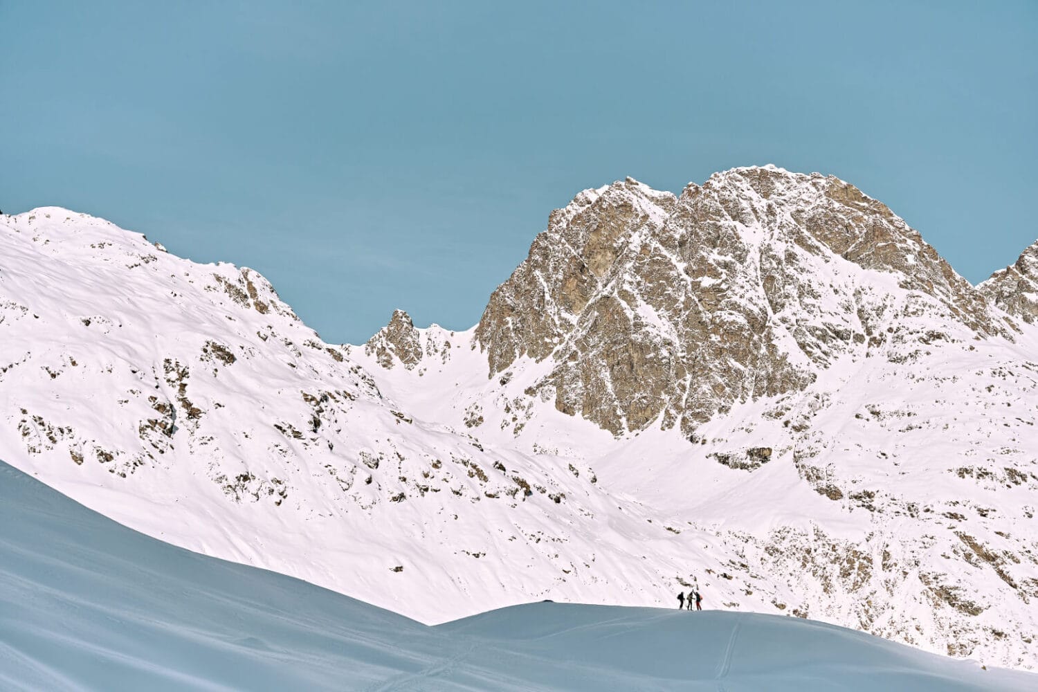 weiße Skipiste, Sonnenschein, Berggipfel im Hintergrund