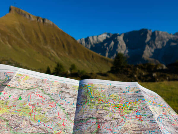 Wanderkarte und bergige Landschaft im Hintergrund