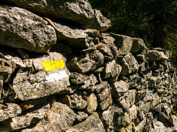 Gelb-weiße Beschilderung auf einer Steinwand